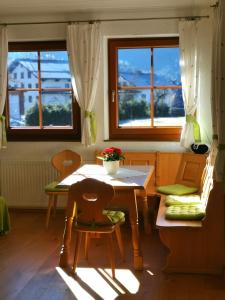 滨湖伦茨Ferienwohnung Schlögelhofer的一间带桌椅和窗户的用餐室