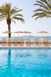 圣胡安包蒂斯塔Grupotel Imperio Playa的一个带椅子和遮阳伞的游泳池以及大海