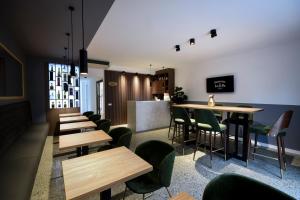 贝尔格莱德Hotel LoRa的餐厅设有木桌和绿色椅子