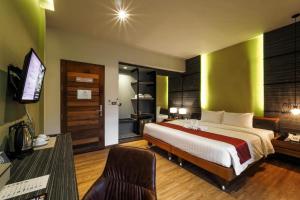 蔻立荣耀黄金酒店的一间卧室配有一张床和一台电视。