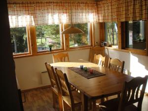 埃克勒Marbyfjärden seaside village Lyckan的一间带木桌和一些窗户的用餐室