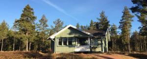 埃克勒Marbyfjärden seaside village Lyckan的森林中间的绿色房子