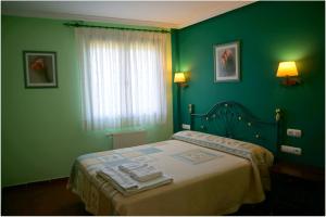 阿韦哈尔Casa Rural La Casa Nueva de Abejar的绿色卧室,配有带毛巾的床