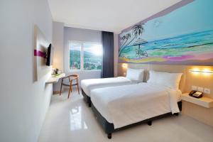 Bitungfavehotel Bitung的酒店客房设有一张床,墙上挂有绘画作品