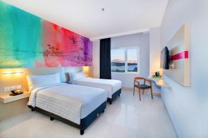 Bitungfavehotel Bitung的酒店客房设有两张床和彩色墙壁。