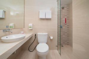 Bitungfavehotel Bitung的浴室配有卫生间、盥洗盆和淋浴。