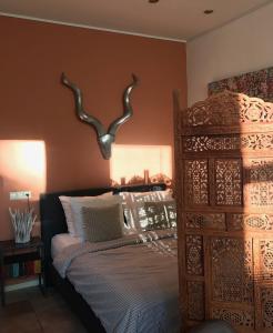 莱顿De Pelgrimsplaats的卧室配有一张床铺,墙上挂着鹿角