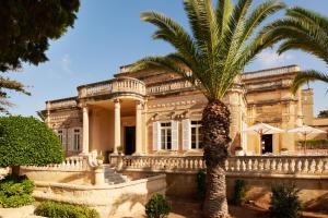 阿塔德Corinthia Palace Malta的一座建筑前的棕榈树