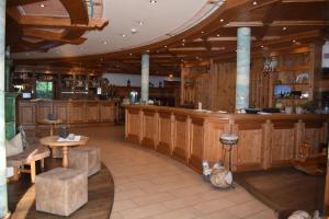 罗森海姆Hotel Happinger Hof的餐厅内的酒吧,设有木墙和桌子