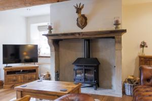 Austwick5 Star Cottage on the Green with Log Burner - Dog Friendly的客厅设有壁炉和电视。