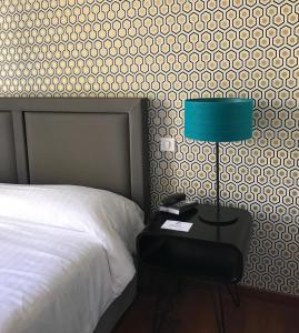 塞特港大酒店的一间卧室配有一张床和一张带台灯的桌子