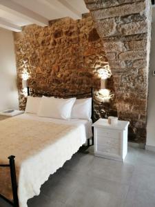 BovinoDormire nel Borgo的一间卧室设有一张床和石墙