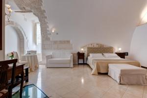 奥斯图尼拉泰拉酒店的酒店客房带两张床和一张桌子以及椅子。