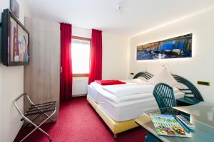 维佩尔菲尔特Landgasthof Tönnes的配有一张床、一张书桌和一扇窗户的酒店客房
