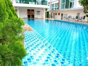 清迈Hinoki Hotel - ONSEN Chiang Mai的一座建筑物边的蓝色瓷砖游泳池