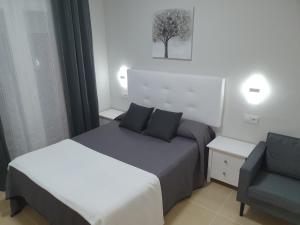 阿尔科斯-德拉弗龙特拉马拉加旅馆的酒店客房,配有两张床和椅子