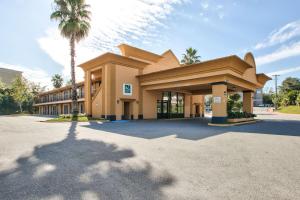塔拉哈西Quality Inn Tallahassee near University的前面有棕榈树的建筑