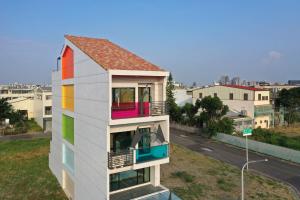 台南台南溜小孩亲子民宿的一座带彩虹窗户和街道的房子