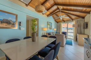 棕榈滩普拉亚琳达海滩度假村 的用餐室以及带桌椅的起居室。