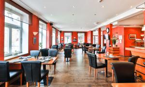卡珀尔恩卡珀尔恩城市酒店的一间带桌椅和红色墙壁的餐厅