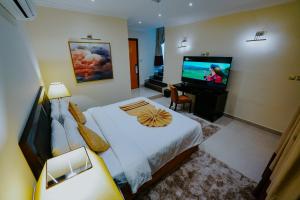 阿布扎比Villaggio Hotel Abu Dhabi的一间卧室配有一张床和一台平面电视