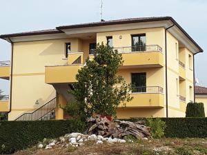 Azzano Decimo阿尔普提科酒店的前面有一棵树的黄色房子