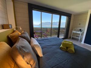 圣若里奥Les Ô d'Annecy的一间卧室设有一张大床和大窗户