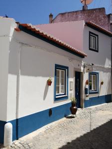 贝雅Maria`s Guesthouse的白色和蓝色的房屋,设有2扇窗户