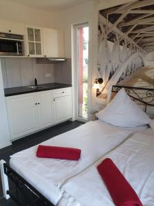 WalleApartmenthaus in Walle的厨房配有两张带红色枕头的白色床。