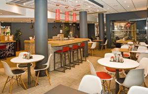 谢菲尔德Ibis Sheffield City的一间带桌椅的餐厅和一间酒吧