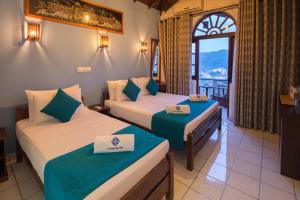 康提Ceyloni Lake Residency的酒店客房设有两张床和窗户。