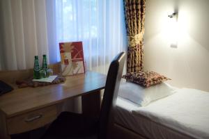 亚诺托维克Hotel Dębowe Wzgórze Wellness & Spa - zarezerwuj w maju 2 noclegi a wypożyczenie rowerów będzie GRATIS!的客房配有一张桌子、一张床和一张书桌。