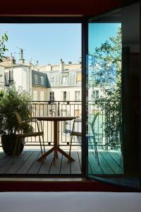 巴黎Hôtel Le Ballu的阳台配有桌椅,享有风景。