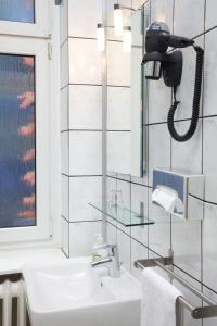 柏林科奈克申艺术酒店的一间带水槽的浴室和墙上的一部电话