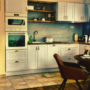 比克伯德兰公寓的厨房配有白色橱柜和桌椅