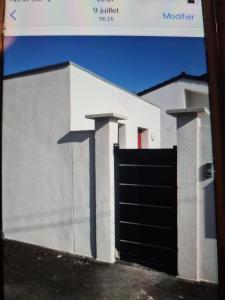 马里尼亚讷Appartement à Marignane的白色的建筑,设有黑色的车库门