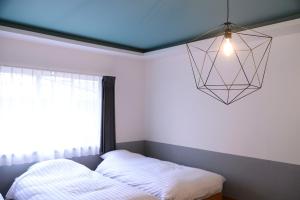高山BEYOND HOTEL Takayama 4th - Vacation STAY 99852的一间卧室配有一张床和吊灯