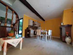 博马尔佐B&B Il Grifo的厨房设有黄色的墙壁和桌椅