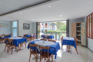 马里亚纳Pousada da Chácara的一间配备有蓝色桌椅的用餐室