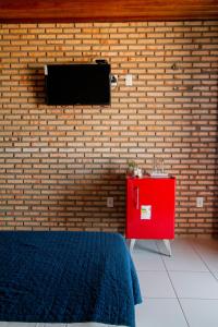 特赖里Pousada Dona Santinha的一间设有砖墙和红色梳妆台的房间