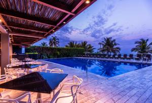 卡塔赫纳卡塔赫纳莫罗斯假日酒店的一个带游泳池和桌椅的度假酒店