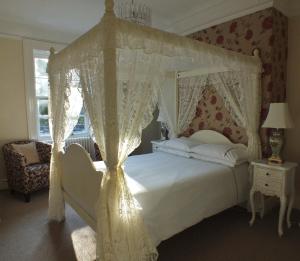 盖茨黑德海德吉菲尔德豪斯酒店的一间卧室配有一张带天蓬的白色床