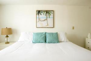 圣徒皮特海滩莫洛伊海湾小屋汽车旅馆的一间卧室配有一张铺有白色床单和棕榈树的床。