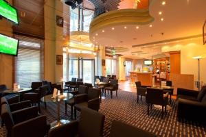 美因河畔法兰克福法兰克福瑞拉科萨酒店总店（高级）的一间带桌椅的餐厅和一间酒吧