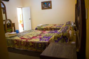 科利马Hotel Morelos Colima的一间卧室配有两张床和五颜六色的被子