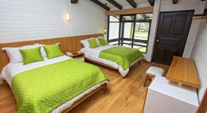 伊瓦拉Hosteria Totoral的一间卧室配有两张带绿床单的床