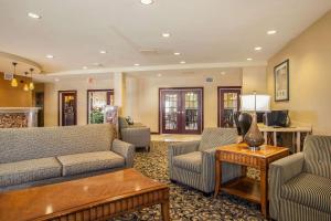 布卢明顿Comfort Suites Bloomington I-55 and I-74的客厅配有沙发、椅子和桌子
