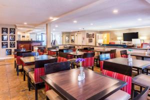 克林顿华盛顿特区安德鲁斯空军基地康福特茵酒店的餐厅设有木桌和鲜花椅子