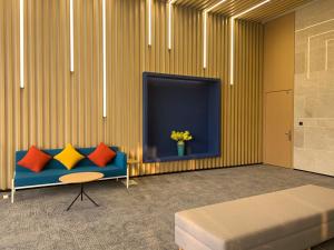 长沙长沙高铁南站智选假日酒店的客厅配有蓝色的沙发和电视