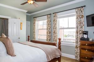 纽波特Almondy Inn Bed & Breakfast的一间卧室设有一张床和两个窗户。